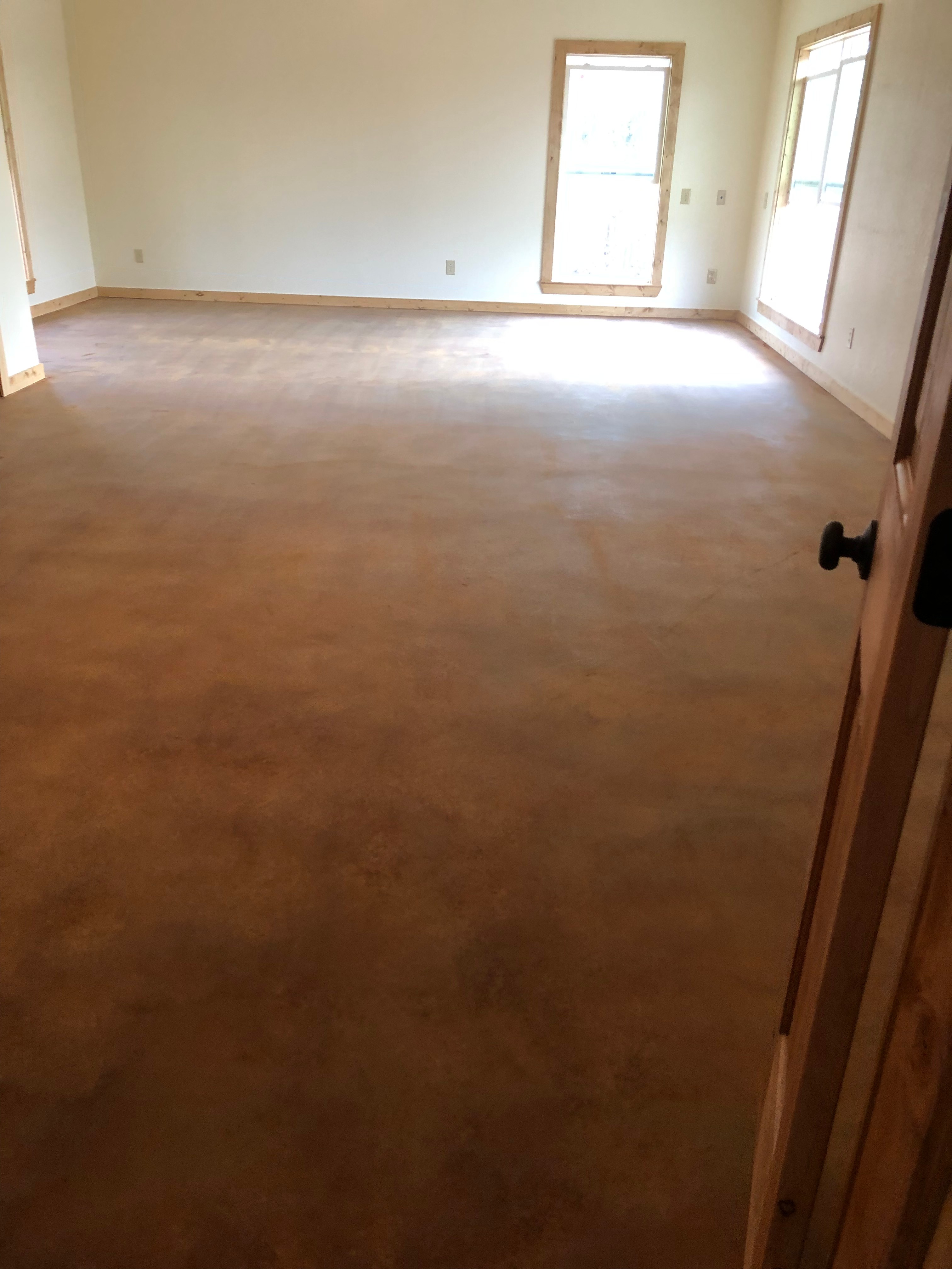 During: Concrete floor after acid stain application showing warm brown mottled tones before final sealing by R.G. Pro Floors